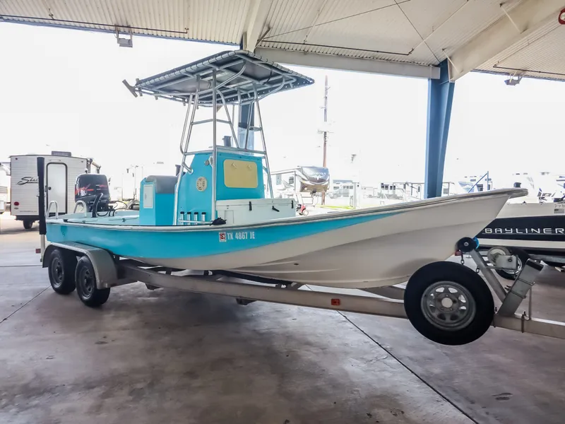 Slide: The Image of A blue and white boat on a trailer is parked in a covered area. - 3