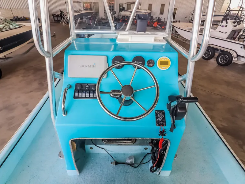 Slide: The Image of A blue boat cockpit with a steering wheel, instruments, and a Garmin device in a storage facility. - 18
