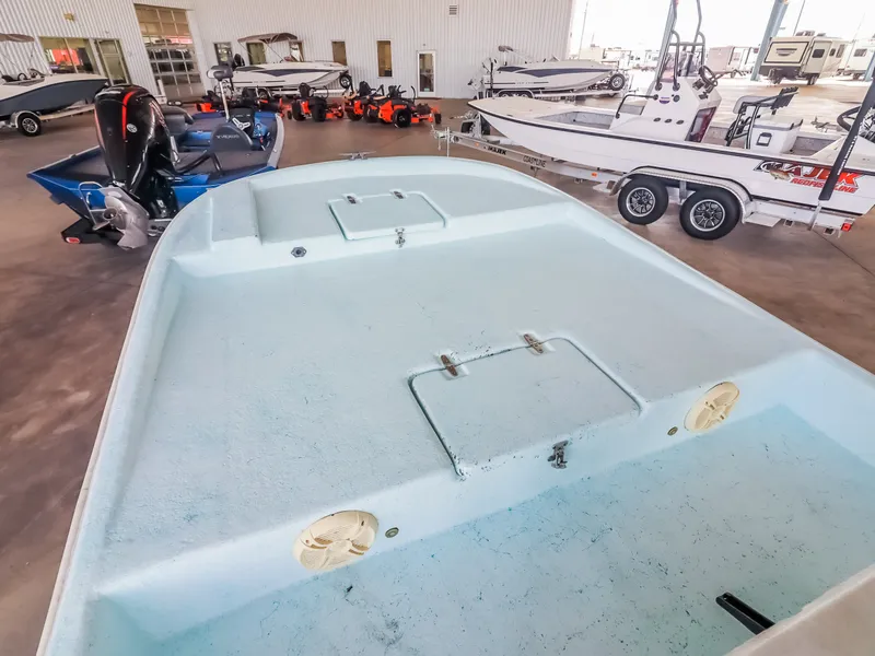 Slide: The Image of An empty boat with an open deck in a warehouse, surrounded by other boats and trailers. - 15