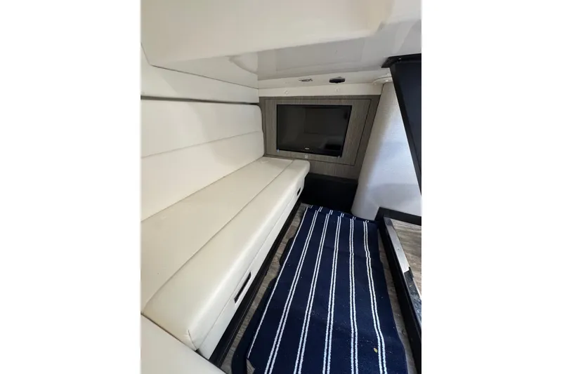 Slide: The Image of Interior of 2021 Monterey 335 Sport Yacht with white seating and striped carpet. - 37