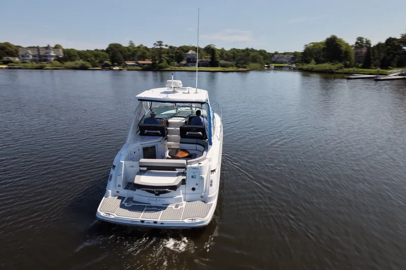Slide: The Image of 2021 Monterey 335 Sport Yacht cruising on a serene lake with lush greenery. - 17
