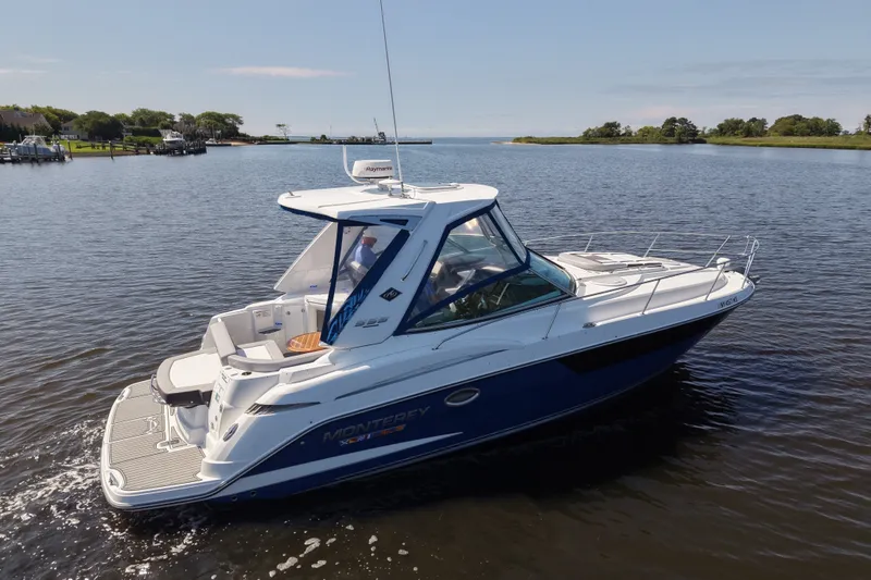 Slide: The Image of 2021 Monterey 335 Sport Yacht cruising on a calm lake under clear skies. - 0