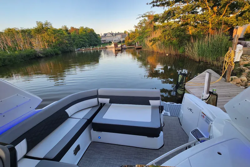 Slide: The Image of 2021 Monterey 335 Sport Yacht docked by serene waterfront with lush greenery. - 51