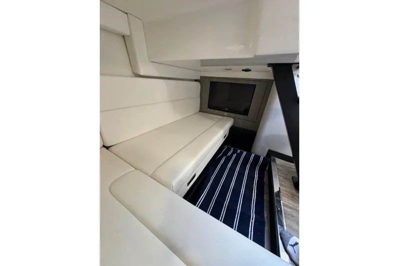 Slide: The Image of Interior of 2021 Monterey 335 Sport Yacht with white seating and a TV. - 38