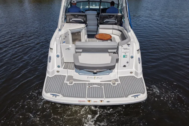 Slide: The Image of 2021 Monterey 335 Sport Yacht on water, rear view with seating and table. - 7