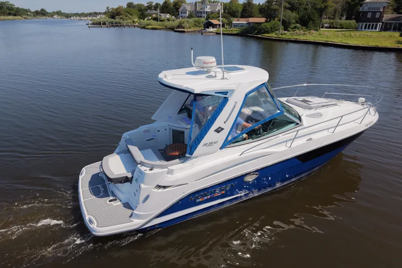 Slide: The Image of 2021 Monterey 335 Sport Yacht cruising on a calm river near lush greenery. - 22