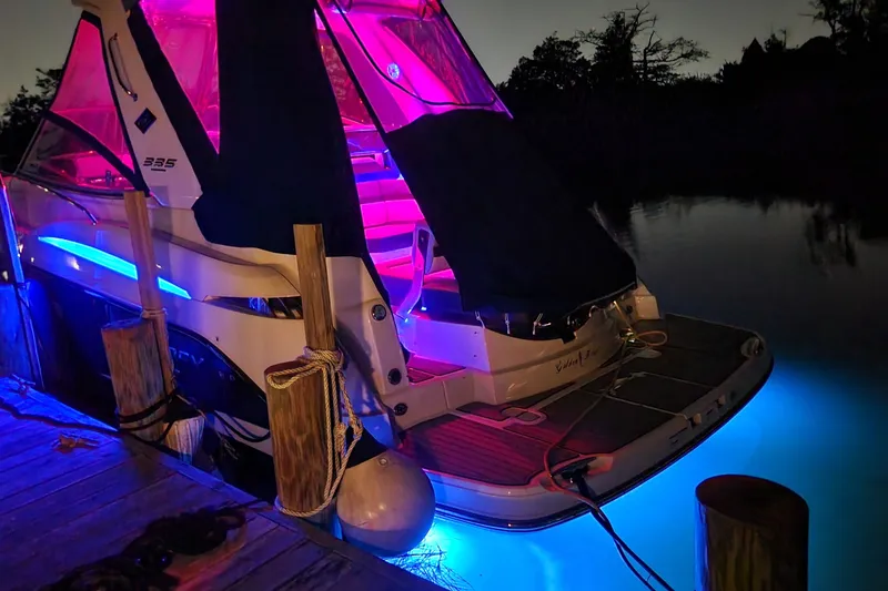 Slide: The Image of 2021 Monterey 335 Sport Yacht docked at night with vibrant LED lighting. - 61