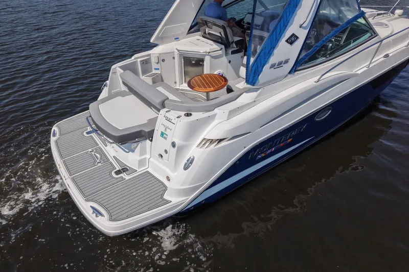 Slide: The Image of 2021 Monterey 335 Sport Yacht cruising on water, showcasing sleek design and spacious deck. - 9