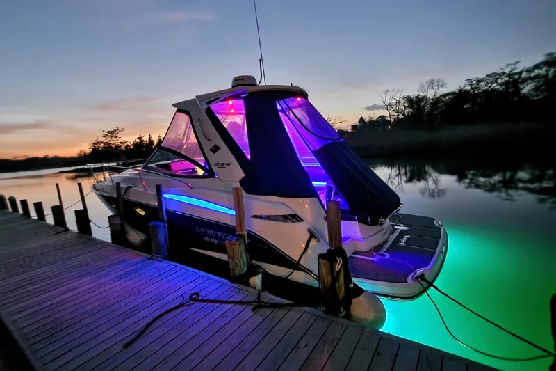 Slide: The Image of 2021 Monterey 335 Sport Yacht docked at sunset with vibrant LED lights. - 58