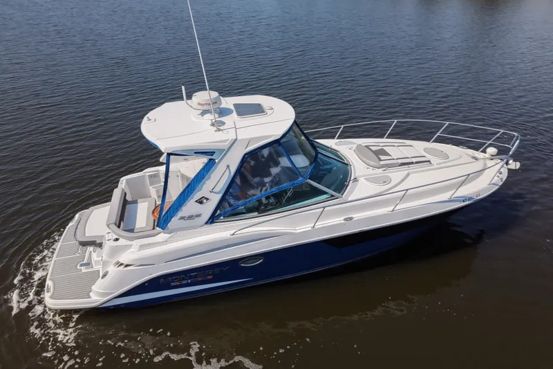 Slide: The Image of 2021 Monterey 335 Sport Yacht cruising on calm waters, side view. - 15
