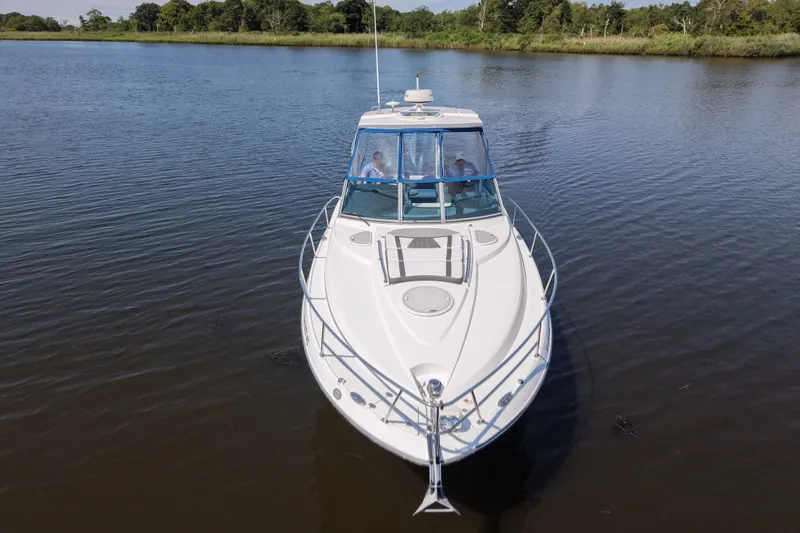 Slide: The Image of 2021 Monterey 335 Sport Yacht cruising on a serene lake with lush greenery. - 19
