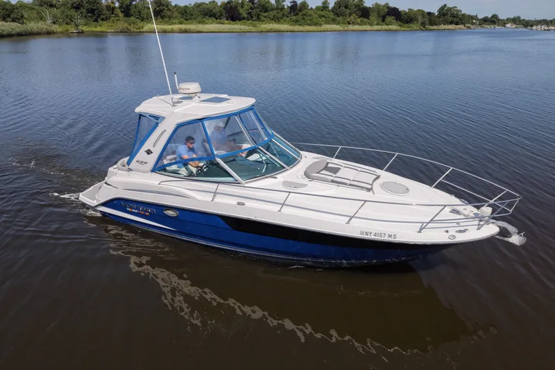 Slide: The Image of 2021 Monterey 335 Sport Yacht cruising on a calm river with lush green shoreline. - 21