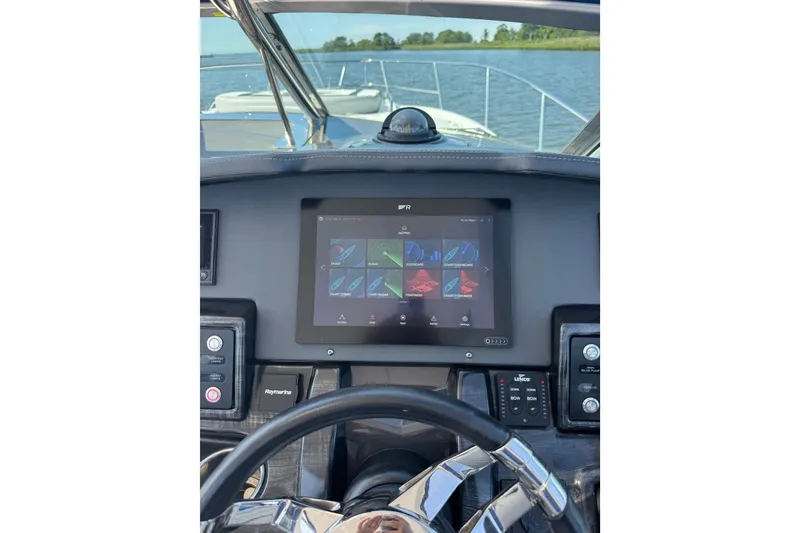 Slide: The Image of 2021 Monterey 335 Sport Yacht dashboard with navigation display on open water. - 48