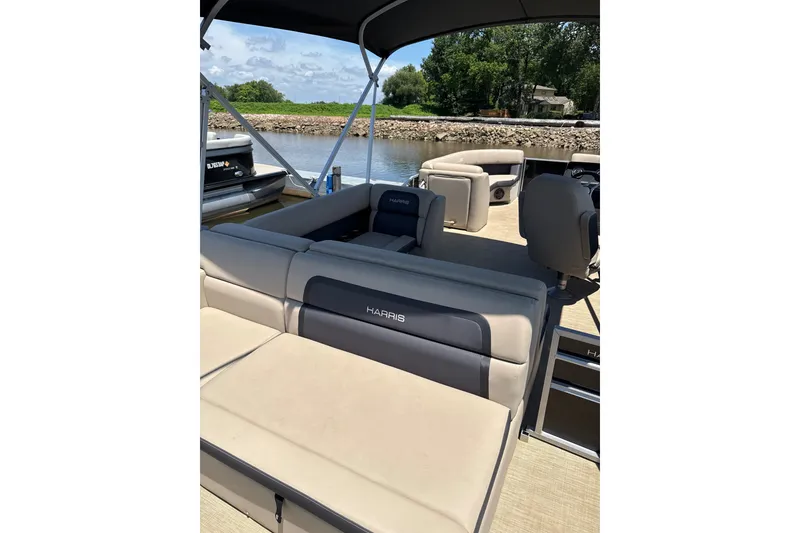 Slide: The Image of 2024 Harris Cruiser 230 pontoon boat interior with comfortable seating and scenic water view. - 8