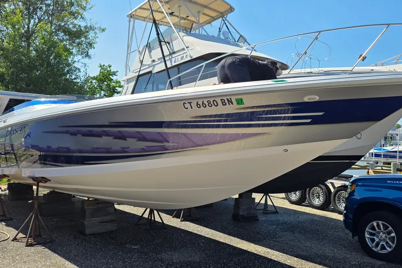 Slide: The Image of 2006 Donzi 38 ZR boat on stands, with vibrant blue and purple graphics. - 2