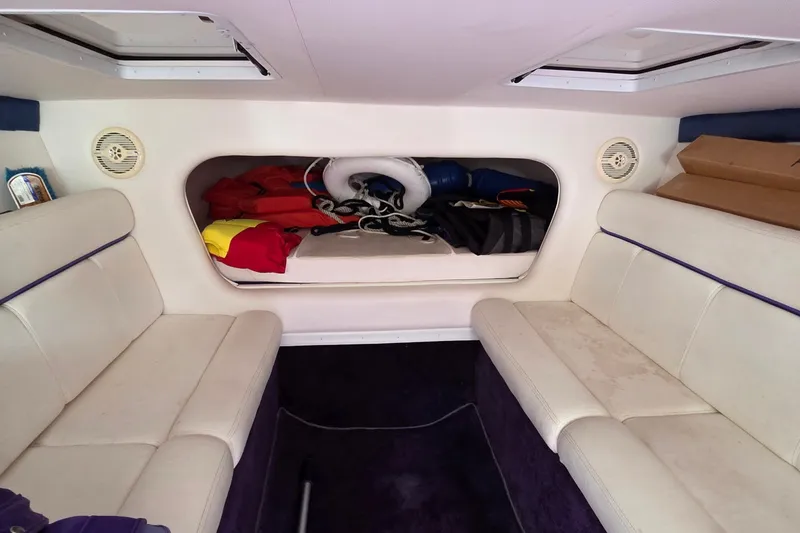 Slide: The Image of Interior of a 2006 Donzi 38 ZR boat with white seating and storage area. - 36