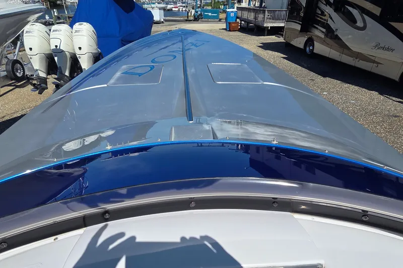 Slide: The Image of 2006 Donzi 38 ZR boat with sleek design, parked near outboard motors and RV. - 25