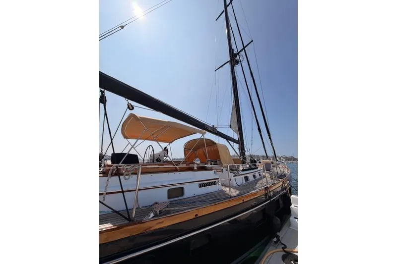 Slide: The Image of 1981 Little Harbor custom sailboat with sleek design and sun canopy, docked under clear sky. - 3