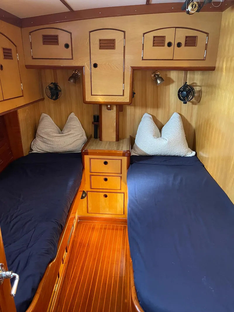 Slide: The Image of 1981 Little Harbor Cruiser cabin with twin beds, wooden interior, and built-in storage. - 10