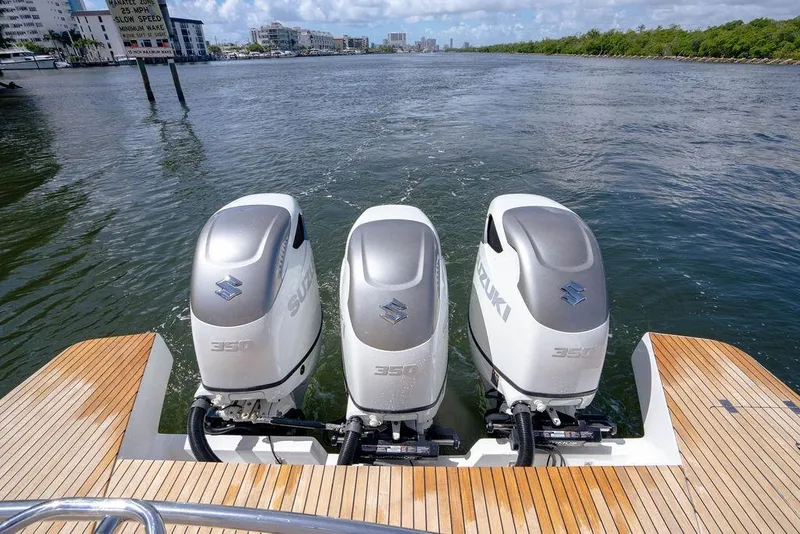 Slide: The Image of Triple Suzuki 350 outboard engines on a 2022 Schaefer 400 Sport boat, docked on water. - 24