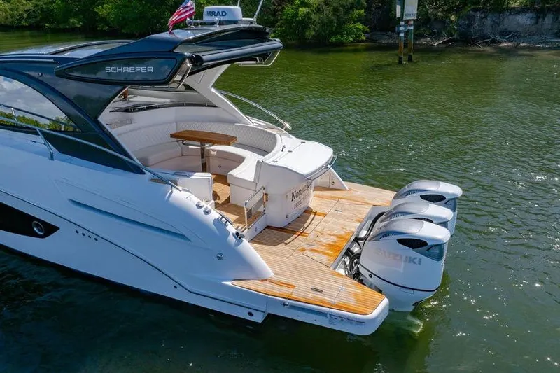 Slide: The Image of 2022 Schaefer 400 Sport yacht with triple Suzuki outboard engines on a calm lake. - 21