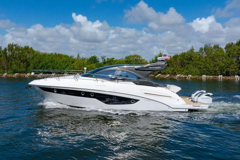 Slide: The Image of 2022 Schaefer 400 Sport yacht cruising on a sunny day, surrounded by lush greenery. - 3