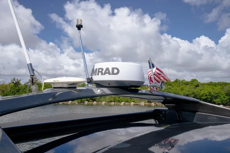 Slide: The Image of 2022 Schaefer 400 Sport boat with radar equipment and American flag, under a cloudy sky. - 50