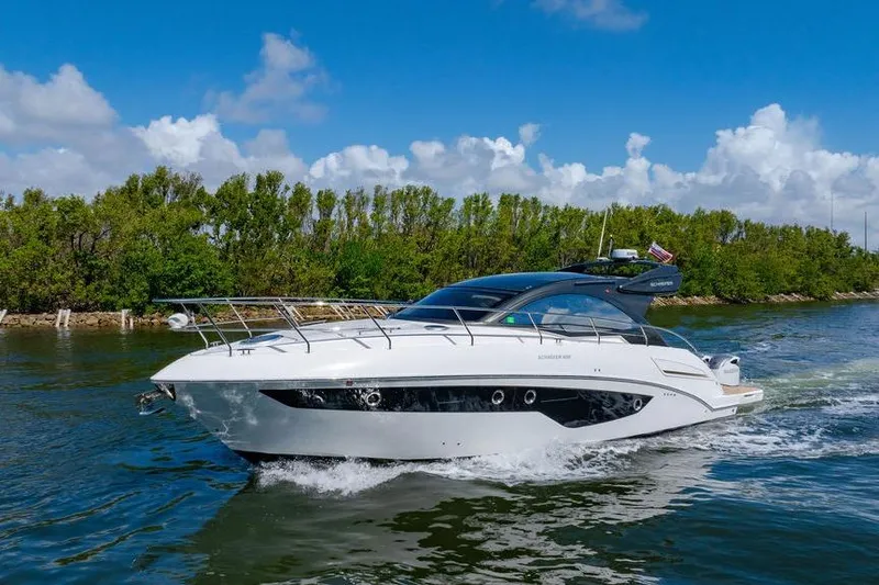 The Image of 2022 Schaefer 400 Sport yacht cruising on a sunny day with lush greenery. - 0