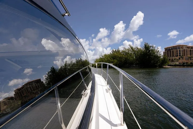 Slide: The Image of 2022 Schaefer 400 Sport yacht cruising on a sunny day near lush shoreline. - 46