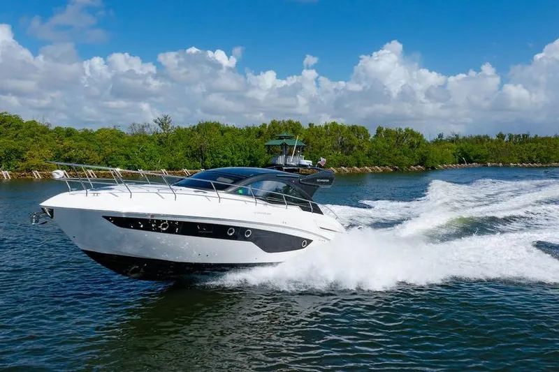 Slide: The Image of 2022 Schaefer 400 Sport yacht cruising on a sunny day with lush greenery. - 5