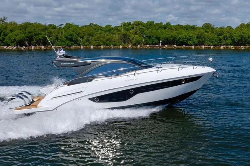 Slide: The Image of 2022 Schaefer 400 Sport yacht cruising on a scenic waterway with lush greenery. - 16