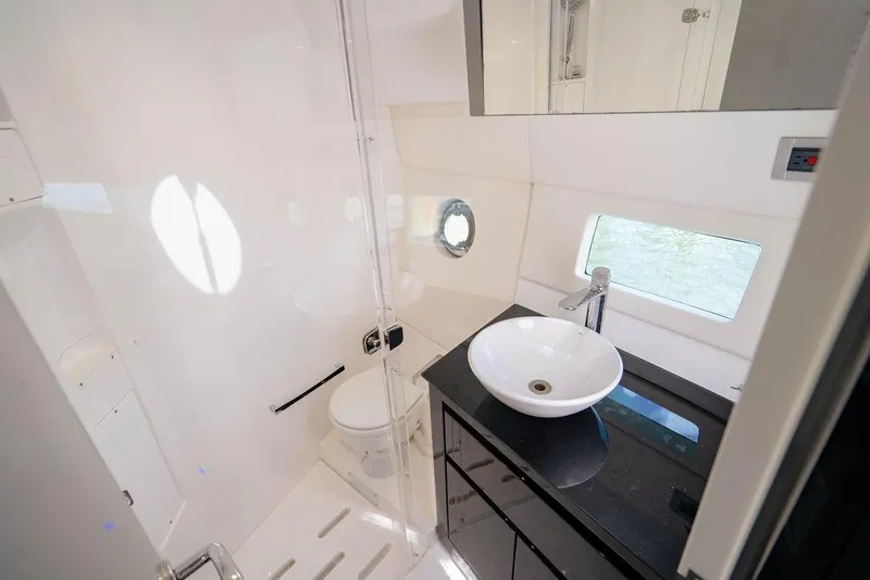Slide: The Image of Modern bathroom interior on 2022 Schaefer 400 Sport yacht, featuring sleek sink and porthole window. - 69