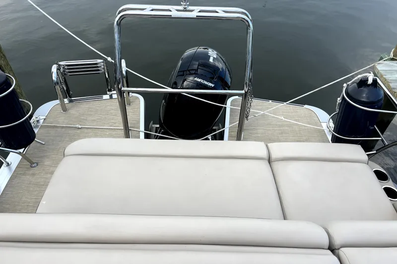 Slide: The Image of 2024 Harris Cruiser 230 boat with Mercury engine, featuring spacious deck and comfortable seating. - 6