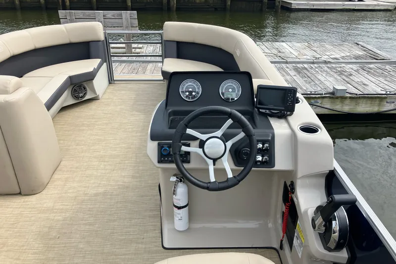 Slide: The Image of 2024 Harris Cruiser 230 boat interior with steering wheel and dashboard controls. - 6
