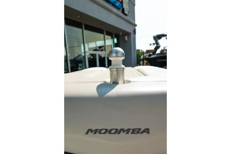 Slide: The Image of 2015 Moomba Mojo boat detail with logo, docked near a building. - 40