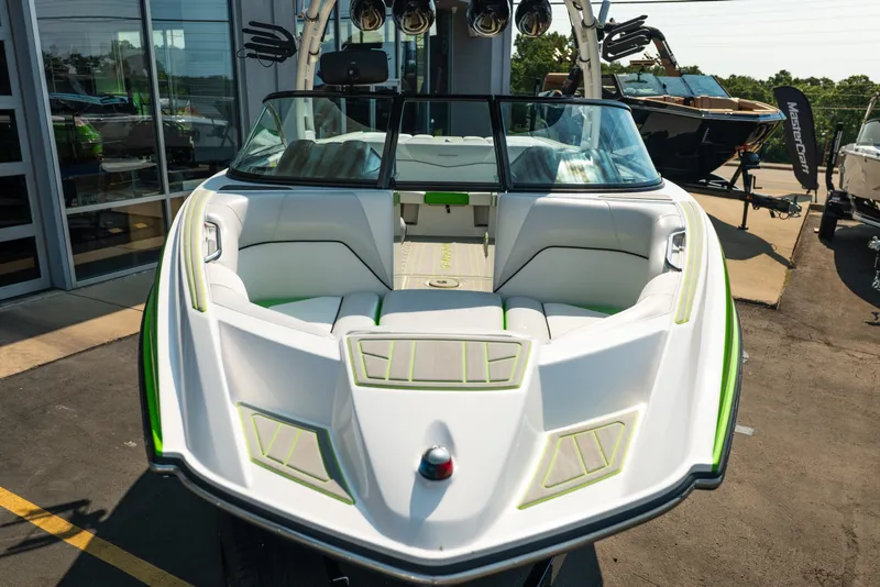 Slide: The Image of 2015 Moomba Mojo boat with white and green interior, displayed outdoors. - 12