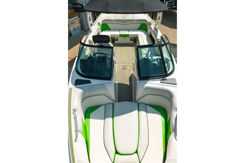 Slide: The Image of 2015 Moomba Mojo boat interior with green and white seating, open windshield, and sleek design. - 35