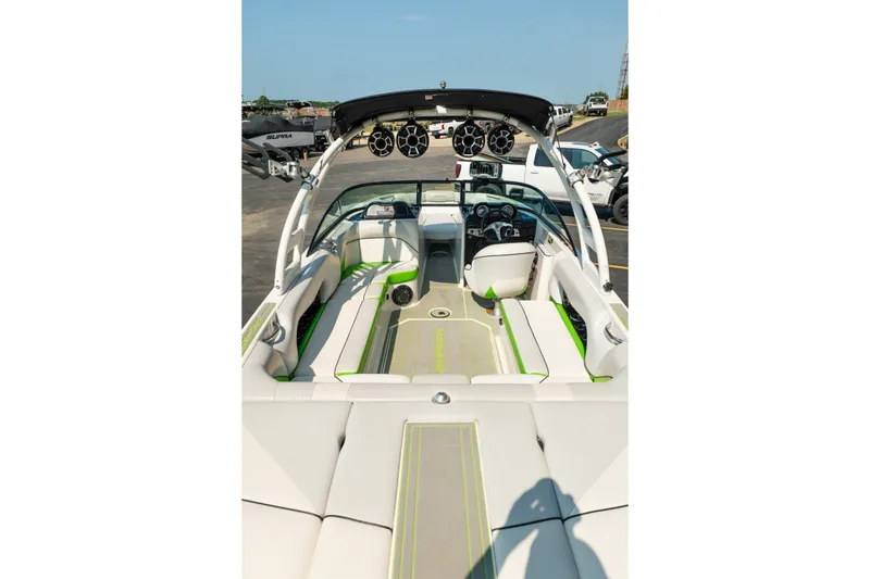 Slide: The Image of 2015 Moomba Mojo boat interior with white and green seating, tower speakers, and steering console. - 18