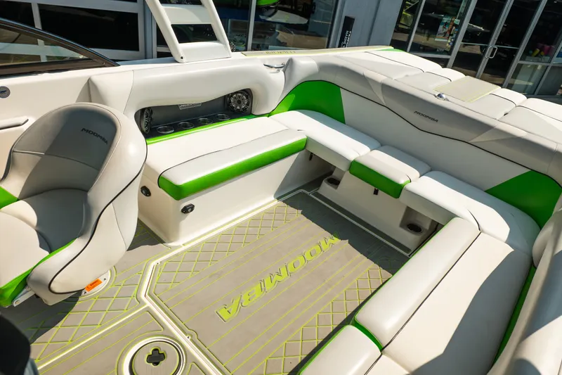 Slide: The Image of 2015 Moomba Mojo boat interior with white and green seating, featuring modern design and spacious layout. - 32