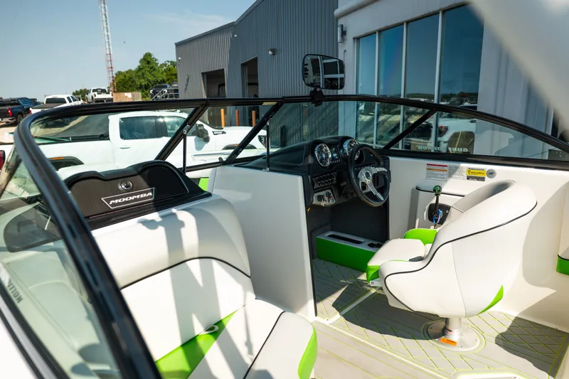 Slide: The Image of 2015 Moomba Mojo boat interior with white and green seating, steering wheel, and dashboard. - 15