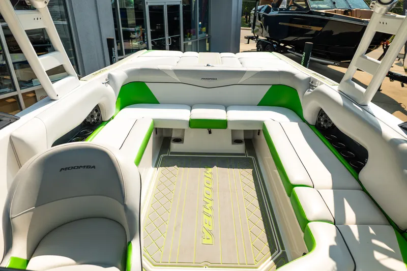 Slide: The Image of 2015 Moomba Mojo boat interior with white and green seating, showcasing spacious design. - 36