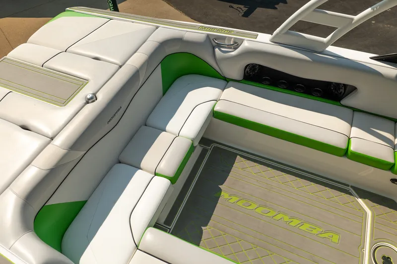 Slide: The Image of 2015 Moomba Mojo boat interior with white and green seating and Moomba-branded flooring. - 20