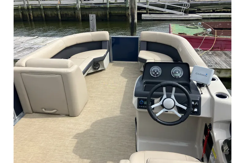 Slide: The Image of 2024 Harris Cruiser 230 boat interior with beige seating and steering console. - 5