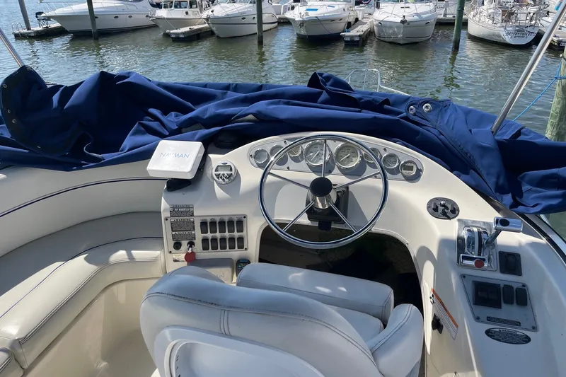 Slide: The Image of Cockpit of 2007 Bayliner Discovery 288 boat with steering wheel and controls, docked at marina. - 32