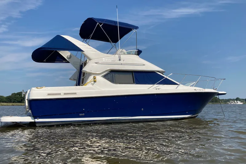 The Image of 2007 Bayliner Discovery 288 boat with blue and white exterior on calm water. - 0