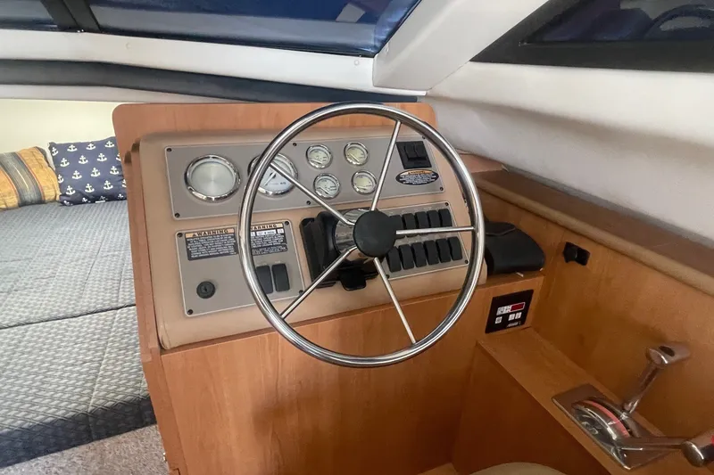Slide: The Image of 2007 Bayliner Discovery 288 helm with steering wheel and control panel. - 12