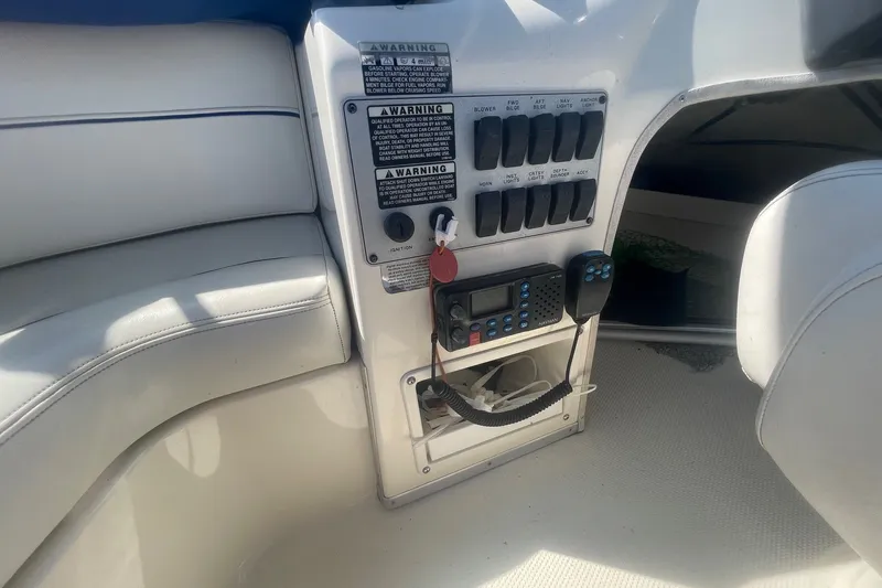 Slide: The Image of Control panel of a 2007 Bayliner Discovery 288 boat with switches and radio. - 36