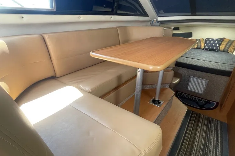 Slide: The Image of Interior of 2007 Bayliner Discovery 288 with beige seating and wooden table. - 10