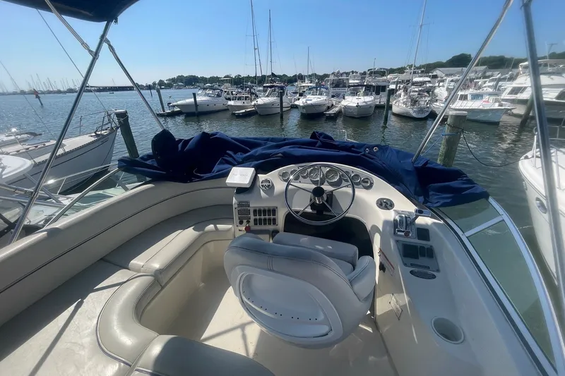 Slide: The Image of 2007 Bayliner Discovery 288 helm view at marina with multiple boats docked. - 33