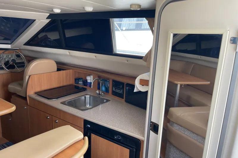 Slide: The Image of 2007 Bayliner Discovery 288 interior with kitchenette, seating area, and helm station. - 7